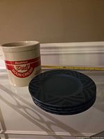 Beatrice crock and four stacked blue Pfaltzgraff plates side by side