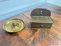 Trinket box closed beside chamberstick, top view