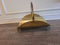 Front view showing brass log holder, handle, feet