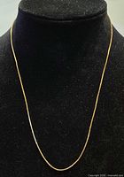 Full view of 50 cm yellow gold box chain on display bust