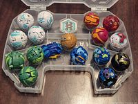 Open storage case showing 15 Bakugan spheres arranged in slots