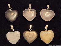 all six heart-shaped stone pendants displayed on black background