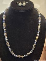 Full view of necklace on display bust with earrings above