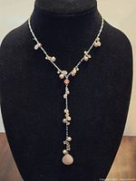 Front view of lariat necklace displaying bead arrangement and pendant