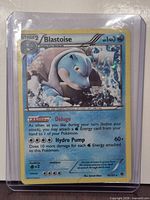 Front view of Blastoise holo card in sleeve and top loader