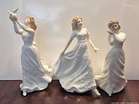 Three white Royal Doulton Sentiments Series figurines standing on table