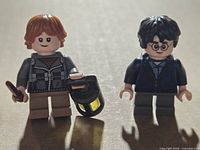 Front view of Ron Weasley and Harry Potter minifigures with accessories