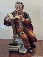 Front view of figurine showing seated professor reading