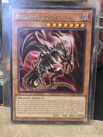 Front of Red-Eyes Soul card in sleeve showing artwork, text, Level, attribute, ATK/DEF, 1st Edition marker