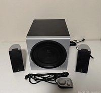 Front view showing subwoofer, two satellites, control pod, cables