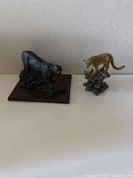 Both mountain lion figurines together for size and comparison
