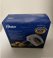 Front view of Oster 2572 mixer box displaying mixer image and attachments