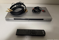 Front view of Sony DVP-NS501P player, remote, and two RCA cables