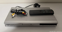 DVD player with remote and RCA cable displayed on top