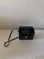 Binoculars inside hard case, shoulder strap visible