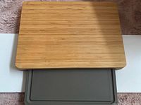 Top view of bamboo cutting board with plastic board partially slid out