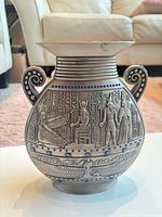 Front view of metal vase showing Egyptian relief and blue gems