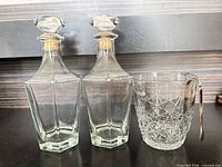 two Bormioli Rocco decanters, cut-glass ice bucket, metal tongs