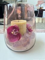 Vase with candle, orchids and crystals front view