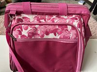Front view of dark pink insulated picnic bag with floral front pocket