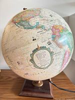 Full view of French illuminated globe showing North America, wood base, power cord