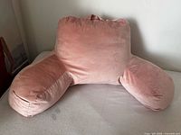 Front view of pink reading pillow showing backrest and arms