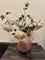 Vase with faux rose arrangement displayed