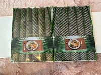 Two shrink-wrapped bundles of rolled woven placemats in retail packaging