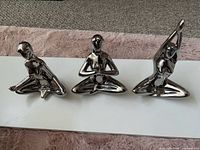 All three polished metal yoga figurines front view