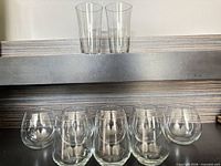 group view showing 2 tall glasses on shelf above 6 small round glasses below