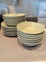 Stacked dinner and side plates alongside stacked bowls