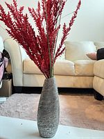 Vase with red stems displayed