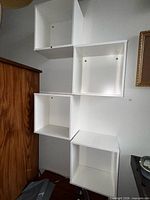 Full view of five white cube shelves mounted in zigzag formation