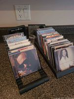Two rows of assorted CDs in racks showing jewel cases and inserts