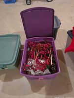 Tote filled with artificial berry stems, pinecones, assorted picks