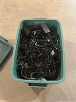 Teal tote filled with tangled green holiday light strands and control plugs