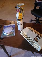 All three items together: packaged LED push light, white fire extinguisher, beige heater