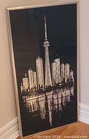 Full view of framed artwork leaning against wall