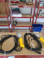 Both handheld work lights coiled on table