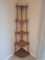 Full view of etagere in corner showing five shelves and finials