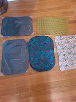 Overview showing gray, chartreuse, teal floral stack, geometric fringed placemat