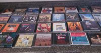 Overview of entire lot laid out on counter showing more than 25 CD cases