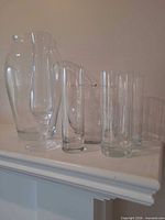 All five clear glass vases grouped on mantel