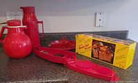 Group shot: two red carafes, red dicer, red serving dish, Miracle-Chef box