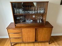 Front view of sideboard with hutch showing drawers, doors and glass display area