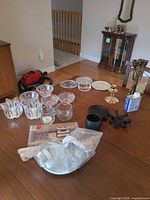 Overview of assorted glass, crystal, brass and cast iron candle holders on dining table