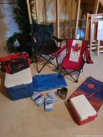 Group shot of chairs, coolers, bag, tarp, ice packs, mug, towel