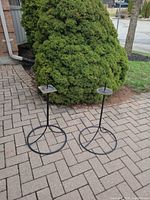 Both wrought iron plant stands outdoors showing full height and bases