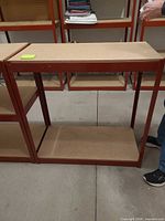 Front view of entire shelving unit showing red frame and two shelves