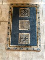 Small patterned blue and beige mat on tile floor